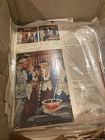 Color print advertising showing colonial era men drinking a brandy product with text description under plastic cover