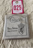 Photo of front of card with text 'Camelot King Arthur King of Camelot' and a crest. Shows original packaging for the coin.