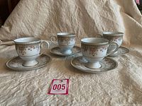 Four Noritake Ireland Morning Jewel footed cups with matching saucers arranged on a cloth surface