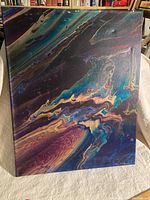 Full view of the abstract acrylic painting showcasing fluid, multicolored patterns in purples, blues, and beiges.