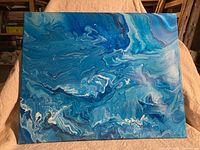 Full view of the original acrylic painting showing abstract blue and white fluid patterns on canvas.