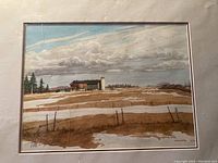 Framed watercolour painting of a barn and silo with a moody sky, showing the full artwork and matting.