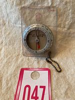 Front view of the vintage Silva compass showing the needle, cardinal points, and the inch ruler on the base.