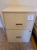 Front view of the beige metal filing cabinet showing two drawers, clean condition with no rust.