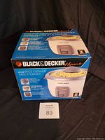 Photo of new in box Black & Decker RC3406C 6-cup rice cooker and steamer. Box is unopened and shows detailed product features.