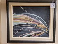 Abstract oil painting featuring flowing colorful shapes on a dark background, within a light wooden frame.