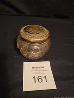 Full view of vintage jewelry holder showing silver-plated lid and cut glass base