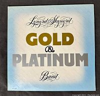 Front cover of the Lynyrd Skynyrd Gold & Platinum vinyl LP album showing title and band name in gold, black, and silver text on a light blue and white gradient background.