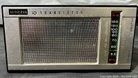 Front view showing large speaker grill and AM tuning scale with volume and tuning controls