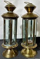 Pair of vintage brass candle lanterns side by side showing etched glass and brass finish