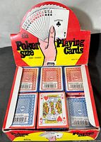 Front view of the display box showing 23 sealed packs of poker size playing cards with red and blue backs visible, standard poker size.