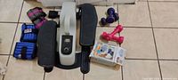 Photo showing exercise equipment including mini stepper, ankle weights, dumbbells, and massage belt box.