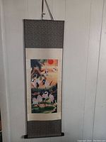 View of the oriental wall hanging scroll showing the full piece with nature and crane artwork mounted on decorative fabric.