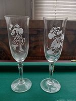 Two clear etched glasses with Mickey Mouse and Minnie Mouse designs shown from front.
