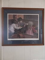 Framed picture showing three children in classroom setting with wood-tone frame and blue matting.