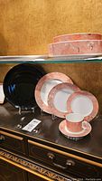 Full view of 4 settings of Villeroy & Boch Sienna dinnerware showing plates, bowls, tea cups and one black charger plate