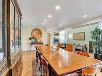 Solid wood Asian dining table shown extended with burled wood top, curve leg design, dark brown perimeter, and decorative protective pads on top.