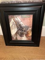 Photo of framed Afrique print featuring the oryx with black wooden frame and visible textured collage art