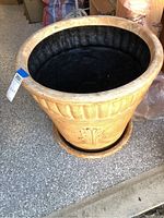 Overall view of the garden pot and matching saucer showing exterior design and condition.