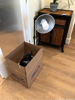 Photo showing one assembled photography light on tripod with spiral compact fluorescent bulb and one packed in box nearby