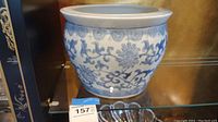 Front view of blue and white porcelain planter with visible floral and vine design in Chinoiserie style.