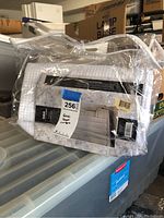 Fabric shower curtain in original packaging with clear plastic bag, showing product label and overall condition.