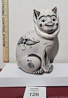 Front view of the large Tonala cat figurine with ruler for size reference.