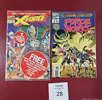 Front view of two Marvel comics on red surface. X-Force #1 comic sealed in bag with promotional stickers. Force Works #10 comic loose with clear cover art.