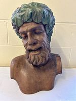Front view of wooden Bacchus bust showing facial carving and leaf wreath