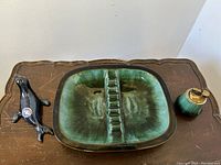 Set showing all three items: ashtray, lighter, and sealion figurine on table