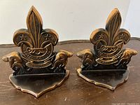Front view of both bronzed metal Boy Scouts emblem bookends showing detailed emblems with beaver figures and fleur-de-lis.
