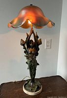 Full view of lamp illuminated, showing overall form and glass shade glow