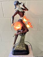 Full view of lamp lit showing dancing lady figure and flower-shaped glass shades