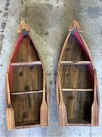 Top view showing both wooden boat-shaped shelves with three wooden shelves inside each, dark finish wood and red sides.