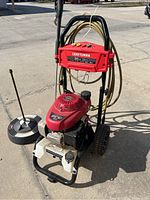 Full frontal view of the Craftsman Honda pressure washer showing red engine, hose, and wheels on concrete surface.