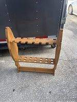 Side view of the pine wooden fishing rod holder showing six V-shaped slots on top and 14 circular holes on bottom tier for holding fishing rods.