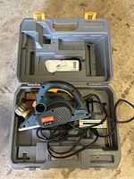 Ryobi electric hand planer in blue color inside molded plastic carry case with user manual