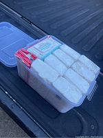 Clear view of the plastic tote filled with individual packs of dry and wet wipes