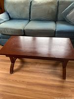 Close-up angle showing the full couch seating area and floor beneath it, highlighting size and fabric wear.