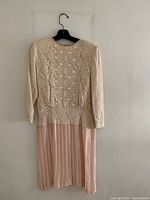 Front view of the peach gown showing lace detail on bodice and pleated skirt.