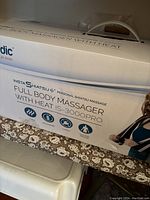 View of the TruMedic InstaShiatsu 3000 Plus massager box showing product name, branding, and features.