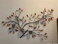 Full view of the wall hanging candle holder showing metal branches with colored glass beads and six glass tealight holders.