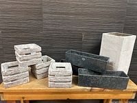 Overview of entire set showing 4 square basket effect planters, 3 rectangular slate effect planters, and 1 tall stone effect planter.