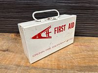 Photo of closed white metal first aid box with red text and logo 'First Aid' and 'Cronin Fire Equipment Limited'