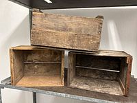 Three vintage wooden crates stacked and placed side by side showing an overall view of their size, shape, and wood condition