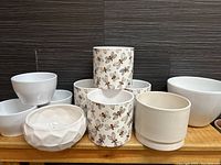 Overview of all ten ceramic planters, six plain white and four with bee pattern