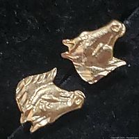 Pair of 10K yellow gold horse head stud earrings shown against black background, highlighting detail and gold color.