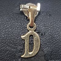 Front view of the 10K yellow gold pendant in letter 'D' shape showing textured details.