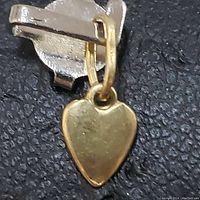 Close-up image of the yellow gold heart-shaped pendant showing the front side and clasp attachment.