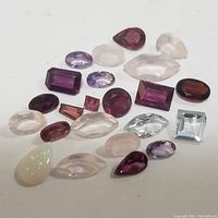 Photo of assorted genuine loose gemstones in multiple cuts and colors on a white background